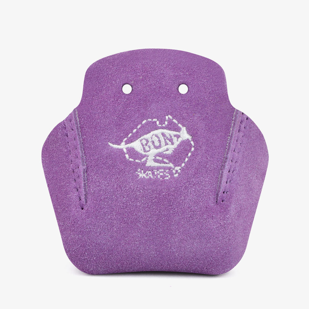 Sunshine Rollers presents the Bont - Stitched Suede Toe Guards (2-Pack), featuring a striking purple design made from durable suede. Each guard is adorned with an embroidered white kangaroo, complemented by the words "Bont Skates" inside a hexagon. The toe guards include two holes at the top and boast a textured surface, making them ideal for avid roller derby enthusiasts.