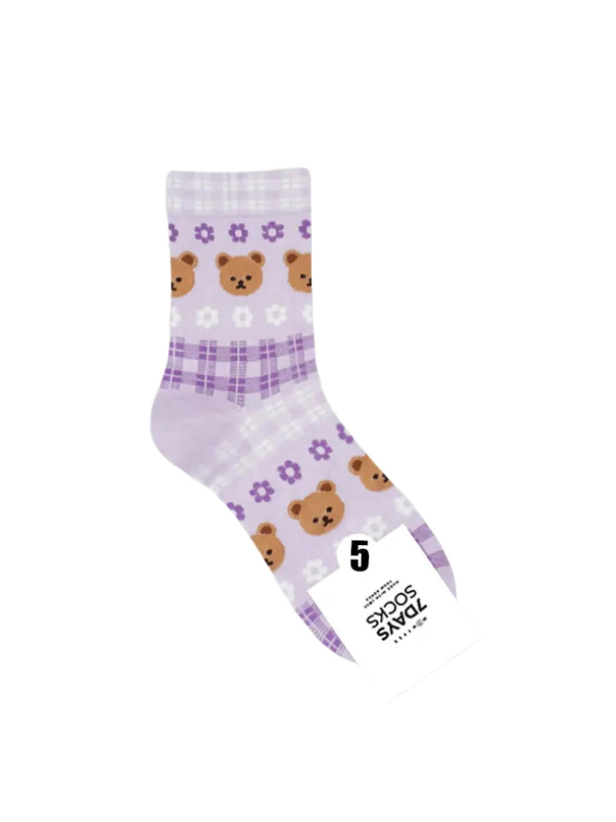 Purple socks with bear pattern and a tag on a light gray background