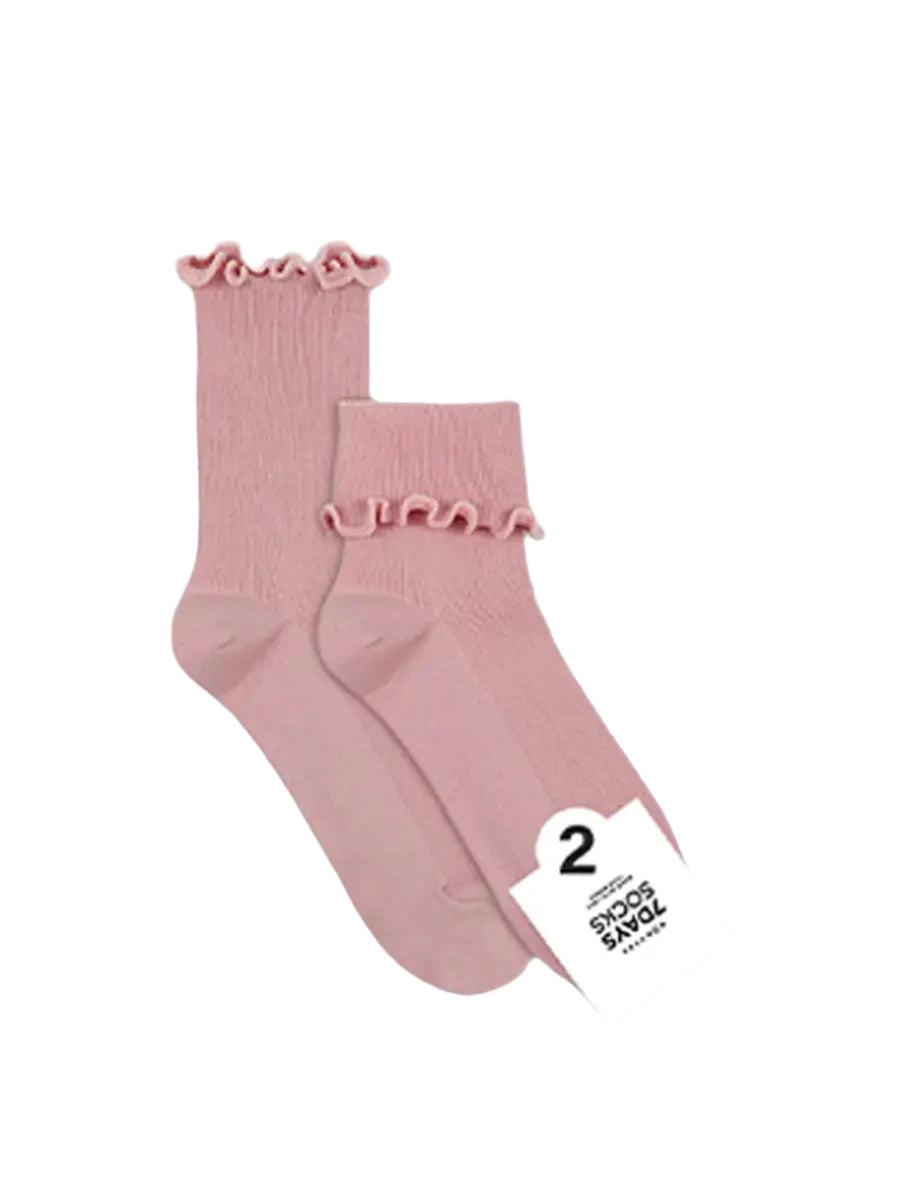 Pair of pink ruffled socks with a tag on a light gray background